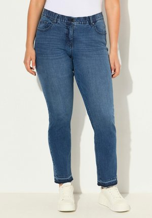 Slim-fit modré džíny z denimu s vysokým elastickým pasem, pěti kapsami a ohrnutými lemy, kombinované s bílými teniskami. Texturovaná tkanina.