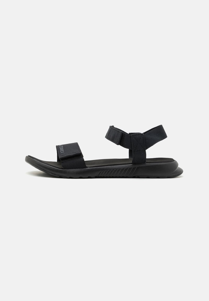 Black sandals with fabric straps and a textured rubber sole. Flat, open design with wide adjustable straps for a secure fit.