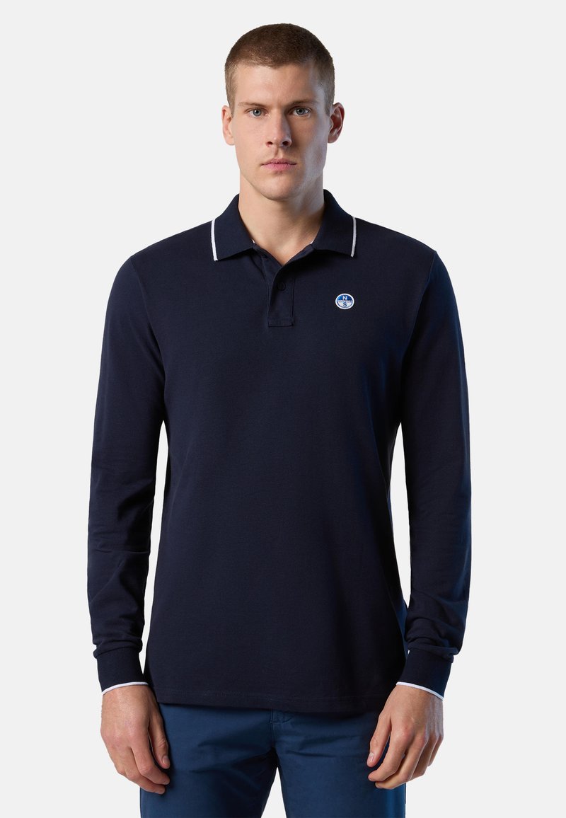 Polo-shirt marine à manches longues en coton, avec un col blanc contrastant et un petit logo rond dans le coin supérieur gauche.