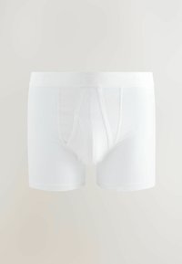 Boxer-briefs en coton blancs avec un ajustement près du corps, une taille élastique avec une marque discrète et une texture lisse et douce.