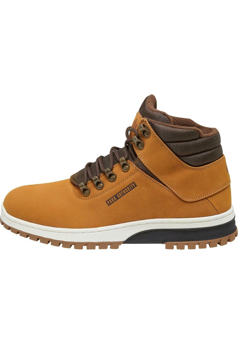 Stivale da trekking marrone in suede con collo imbottito, occhielli in metallo e suola in gomma resistente. Presenta una intersuola bianca e dettagli del logo.