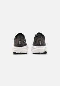 Schwarze Laufschuhe mit einer strukturierten Oberseite, weißer Zwischensohle und schwarzer Außensohle. Verfügt über Markenkennzeichnung und eine Zuglasche an der Ferse.