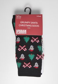 Fekete zoknik Grumpy Santa mintával, cukorbotokkal és karácsonyfákkal; 3 párat tartalmaz; a csomagoláson méretválaszték és márka szerepel.