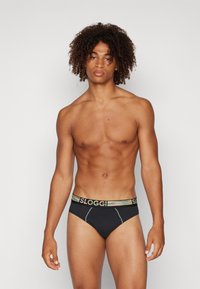 Schwarze Boxershorts mit einem mehrfarbigen elastischen Bund mit "SLOGGI"-Markierung, glattem Stoff und Kontrastnähten.