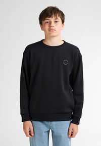 Sudadera negra de tejido suave con cuello redondo y mangas largas. Incluye un pequeño detalle de logo en la parte izquierda del pecho.