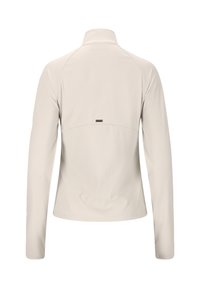 Hellbeige Langarmjacke mit hohem Kragen, gerippter Textur im unteren Rückenbereich und einem kleinen metallischen Logodetail.