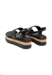 Sandales à plateforme en cuir noir avec des doubles sangles, une semelle intercalaire en liège et une semelle en caoutchouc. Comprend une boucle réglable pour un ajustement.