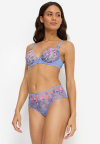 Σετ ελαφρώς μπλε εσώρουχα με διάφανο σουτ ιέν διακοσμημένο με κεντήματα λουλουδιών σε ροζ και μωβ, συνοδευόμενο από ταιριαστά σλιπ με ψηλή μέση και διακοσμητικά στοιχεία.