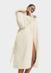 Lang cremefarvet badekåbe lavet af blødt, quiltet stof med hætte, med bindebånd i taljen, sideslids og tekstureret mønster.