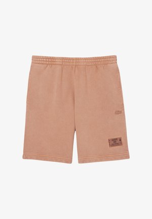 Pantalones cortos de color marrón claro hechos de una tela suave con una cintura elástica. Cuenta con un bolsillo lateral y una etiqueta de marca en el dobladillo.
