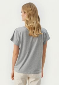 Grå kortärmad t-shirt med rund halsringning och avslappnad passform, tillverkad av mjukt tyg, med en slät textur och minimala sömdetaljer.