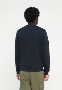Navy blue sweatshirt with a crew neck, ribbed cuffs and hem. Made from soft fabric, featuring a simple design with no visible logos.