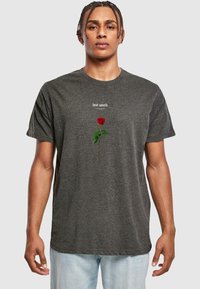 Grå bomulls t-skjorte med et rødt rose-motiv og teksten "lost youth" over. Korte ermer og en avslappet passform.