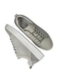 Lichtgrijze sneakers van leer en suede, met een gestructureerde rubberen zool, vetersluiting en een hieltab voor gemakkelijk aan- en uittrekken.