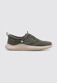 Zapato de ante verde con puntera redondeada, diseño de cordones y suela de goma beige gruesa con ranuras horizontales.