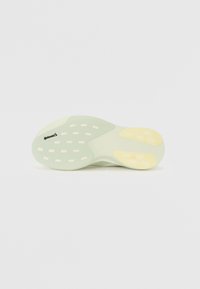 Suola di scarpe verde e gialla, caratterizzata da una texture liscia, una forma curva e numerosi ritagli circolari per flessibilità e aderenza.