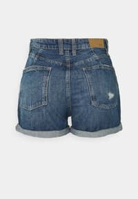 Pantalones cortos de mezclilla azul con dobladillos vueltos, dos bolsillos traseros, pasadores para cinturón y un pequeño detalle desgastado en el bolsillo derecho.