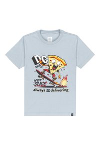 Svetlomodré tričko s potlačou postavičky pizze na skateboarde, so všelijakými farbami textu: "DC Shoe Co. HOT SLICE vždy dodáva."