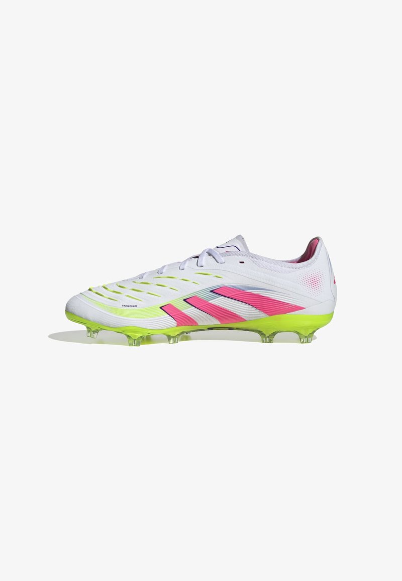 White football cleat with pink and green accents, featuring a streamlined design, textured upper, and transparent sole with studs.