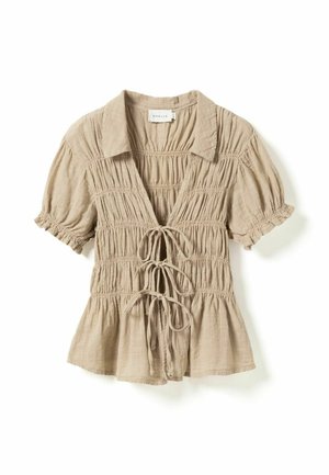Beżowa bluzka na krótki rękaw z kołnierzykiem, marszczoną tkaniną, trzema zapięciami na wiązania z przodu oraz lekko rozszerzanym dołem.