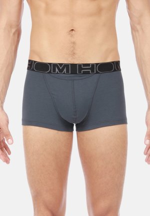 Dunkelgraue Boxershorts mit einem schwarzen Bund, der das "HOM"-Logo trägt. Der Stoff ist glatt, mit flachen Nähten und einem enganliegenden Design.
