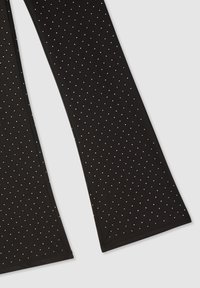 Czarne legginsy o gładkiej fakturze, z całościowym wzorem małych srebrnych ćwieków, które dodają detalu i wizualnego interesu.