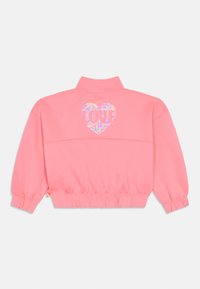 Ροζ κοντό μπουφάν με ψηλό γιακά, με λαμπερό καρδιακό γραφικό "LOVE" στην πλάτη και ελαστικά μανσέτα στα μανίκια.