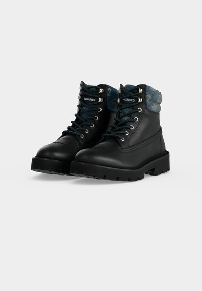 Paire de bottes en cuir noir à lacets avec semelles épaisses et col en tissu bleu matelassé présentant un imprimé à motifs.