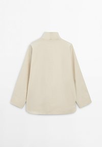 Beige lange mouwen jack met hoge kraag, gezien vanaf de achterkant, met een rechte snit en minimale naaddetails.