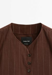 Brun skjorte med knaplukning og V-hals, med hvide striber, mørke knapper og et mærke, der siger "Massimo Dutti, Made in Portugal."