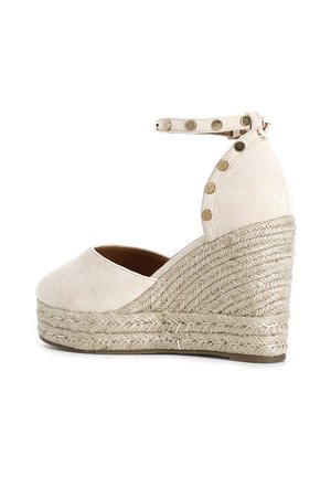 Espadrille con zeppa beige, tomaia in suede testurizzato, cinturino alla caviglia con borchie decorative dorate e tacco avvolto in corda naturale.
