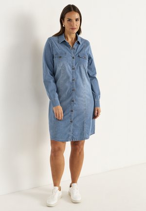 Denimmekko, vaaleansininen, napit edessä, pitkät hihat, kaksi rintataskua, suora leikkaus, pehmeä materiaali, yhdistetty valkoisiin lenkkareihin.