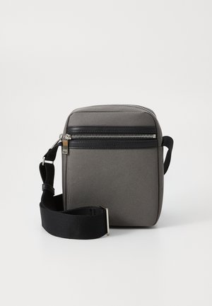 Gray fabric crossbody bag with a black zippered pocket, adjustable strap, and rectangular shape. Features a smooth texture and metal hardware.