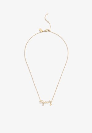 Collier ton or avec le mot "coach" en cursive, accompagné d'un petit cœur pendu et d'un accent en pierre précieuse. Chaîne fine avec fermoir.