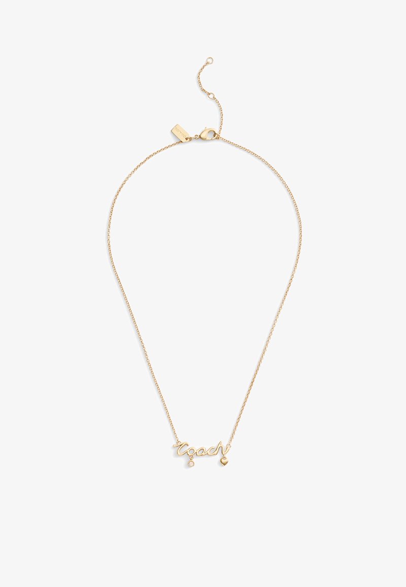 Collier ton or avec le mot "coach" en cursive, accompagné d'un petit cœur pendu et d'un accent en pierre précieuse. Chaîne fine avec fermoir.