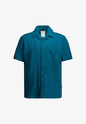 Cămașă verde-albăstru cu mâneci scurte, nasturi, guler și un buzunar la piept cu o mică emblemă cusută.