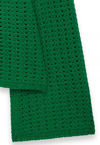 Groene gebreide stof met een gestructureerd, open weefpatroon. De randen zijn netjes afgewerkt en hebben een consistente steekdetail door het geheel.
