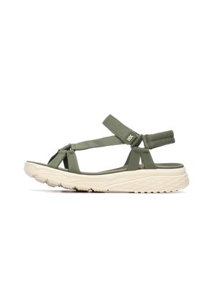 Sandalias de tela verde con correas cruzadas y cierre ajustable de Velcro. Suela ligera de color crema con características de agarre texturizado.