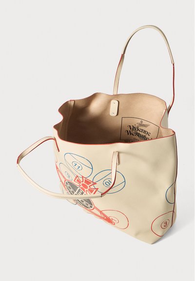Bežs Vivienne Westwood tote soma ar sarkaniem malām, zilu un sarkanu numurētu loku dizainu, atvērta augša un divām plānām plecu siksnām.