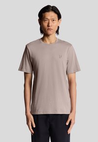 T-shirt a maniche corte color taupe realizzato in morbido cotone, con scollatura rotonda e un piccolo logo ricamato sul lato sinistro del petto.