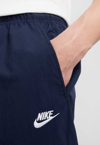 Marineblå Nike shorts lavet af letvægtsstof med elastisk talje, med en sidelomme og et hvidt broderet logo.