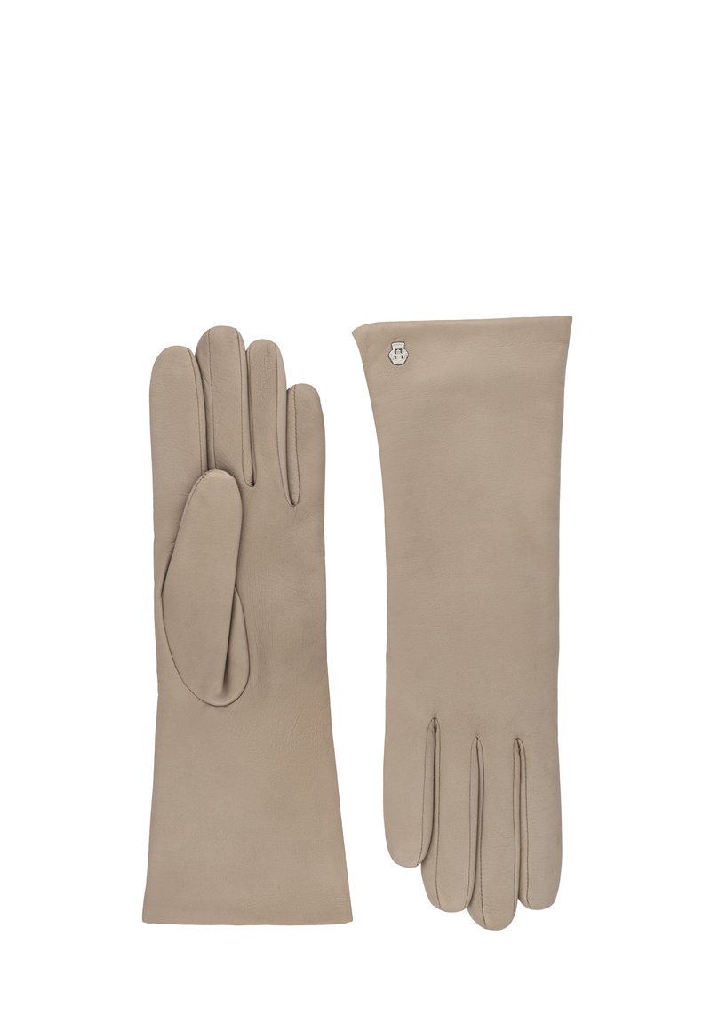 Ein Paar beigefarbene Lederhandschuhe mit einem kleinen silbernen Emblem nahe dem Handgelenk auf einem Handschuh, flach ausgelegt mit ausgestreckten Fingern.