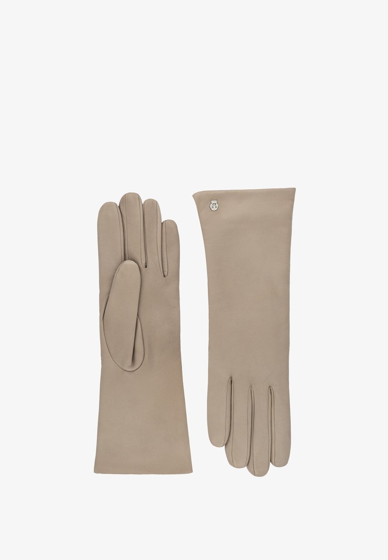 Ein Paar beigefarbene Lederhandschuhe mit einem kleinen silbernen Emblem nahe dem Handgelenk auf einem Handschuh, flach ausgelegt mit ausgestreckten Fingern.