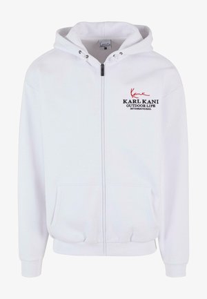 Balta užtrauktuku užsijungianti bliuzoninė striukė, pagaminta iš medvilnės, su pintine kepure, priekinėmis kišenėmis ir raudonai juodu siuvinėjimu.