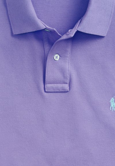 Hellviolettes Polohemd mit zwei Knöpfen, geripptem Kragen und besticktem hellblauem Logo auf der rechten Seite.