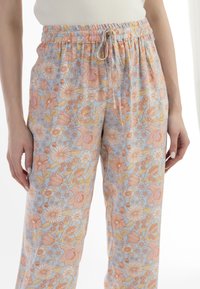 Lichtblauwe bloemenbroek met een drawstring tailleband, van lichtgewicht stof, met patronen van roze en gele bloemen over de hele broek.