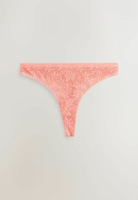 Tanga din dantelă de culoare coral deschis, cu un model floral, textura delicată și acoperire minimă, cu laterale înguste și design spate în formă de V.