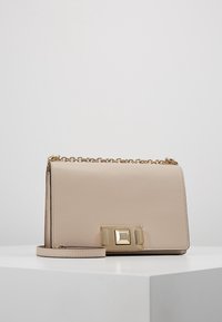 Borsa a spalla in pelle beige con chiusura e catena dorate, caratterizzata da una superficie testurizzata e da una forma rettangolare.