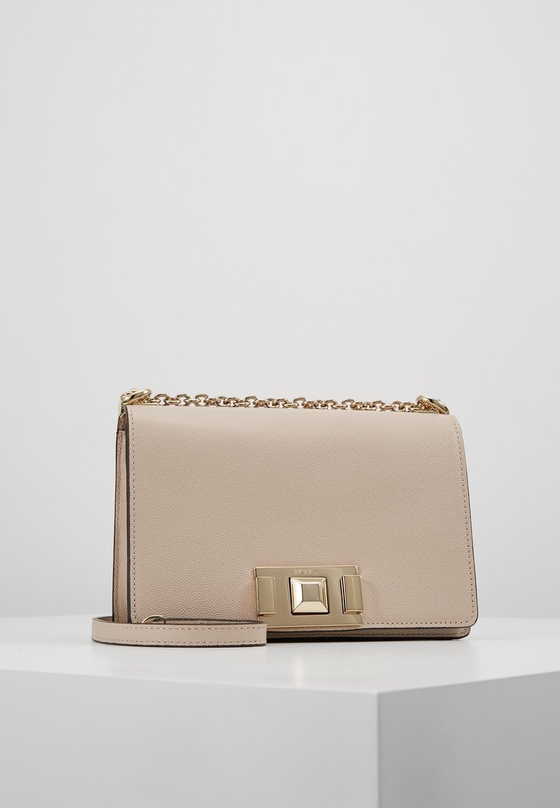 Borsa a spalla in pelle beige con chiusura e catena dorate, caratterizzata da una superficie testurizzata e da una forma rettangolare.