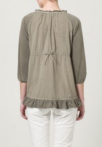 Blusa verde oliva con maniche a tre quarti, orlo arricciato e vita con cordoncino. Tessuto morbido con dettaglio di scollatura arricciata.